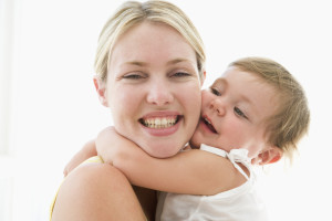 Mother and baby indoors hugging and smiling